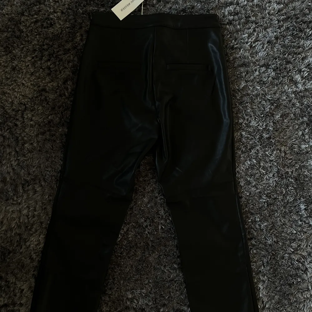 Helt nya svarta skinnbyxor från Carin Wester i storlek 40, en kort modell. Jeans & Byxor.