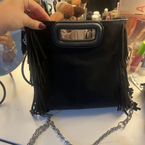 Maje väska - Säljer denna väska från Maje, den är i den stora modellen och är i superfint skick. Jag har både orginal bandet som man får med, men har även köpt till den långa kedjan från Maje som man får med!