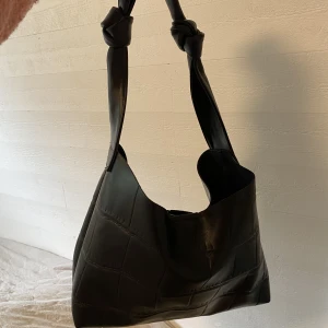 Svart handväska - Svart handväska med knutar. Perfekt storlek. 