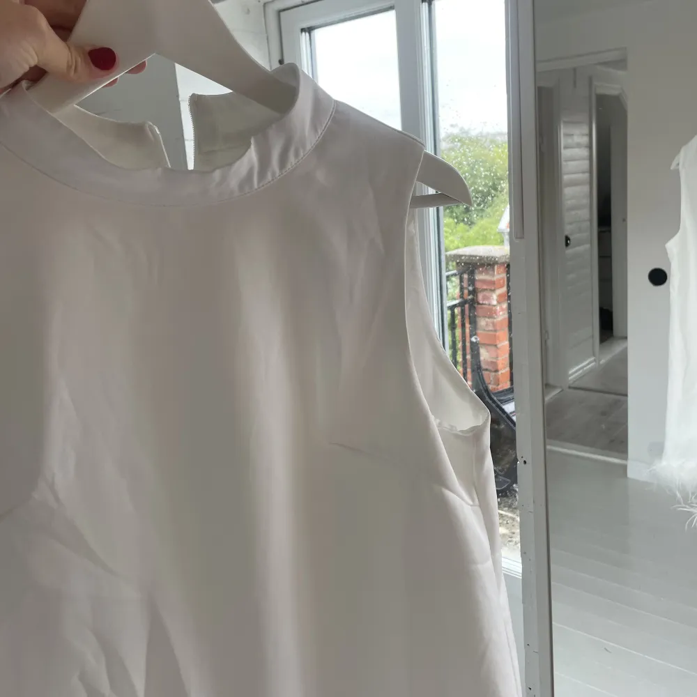 Säljer denna vita klänning med fjädrar jag aldrig använt . Klänningar.