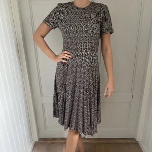 Söt prickig klänning - Fin prickig klänning från H&M. Svart med sandfärgade prickar. Härligt fall.