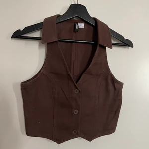 Brun väst tröja  - Brun väst tröja med knappar från H&M. Storlek 36 men passar som 34. Använd en gång. Köpare står för frakt. 