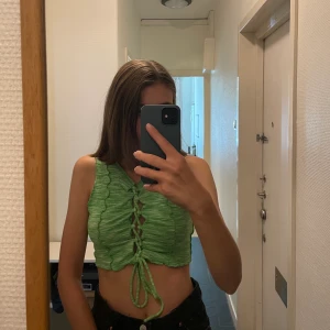 Topp med knytning - Grön/neongrön topp med knytning. Är i storlek M men bär vanligtvis S 