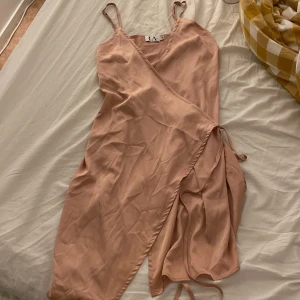 Sidenklänning  - En rosa klänning med slits och knytning från Linn ahlborgs kollektion med NA-KD. För liten för mig
