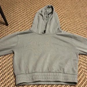 Grön luvtröja med dragsko nertill - Den är mörkgrön och lite kortare, använd typ 2 ggr jag säljer denna då jag inte använder den mer