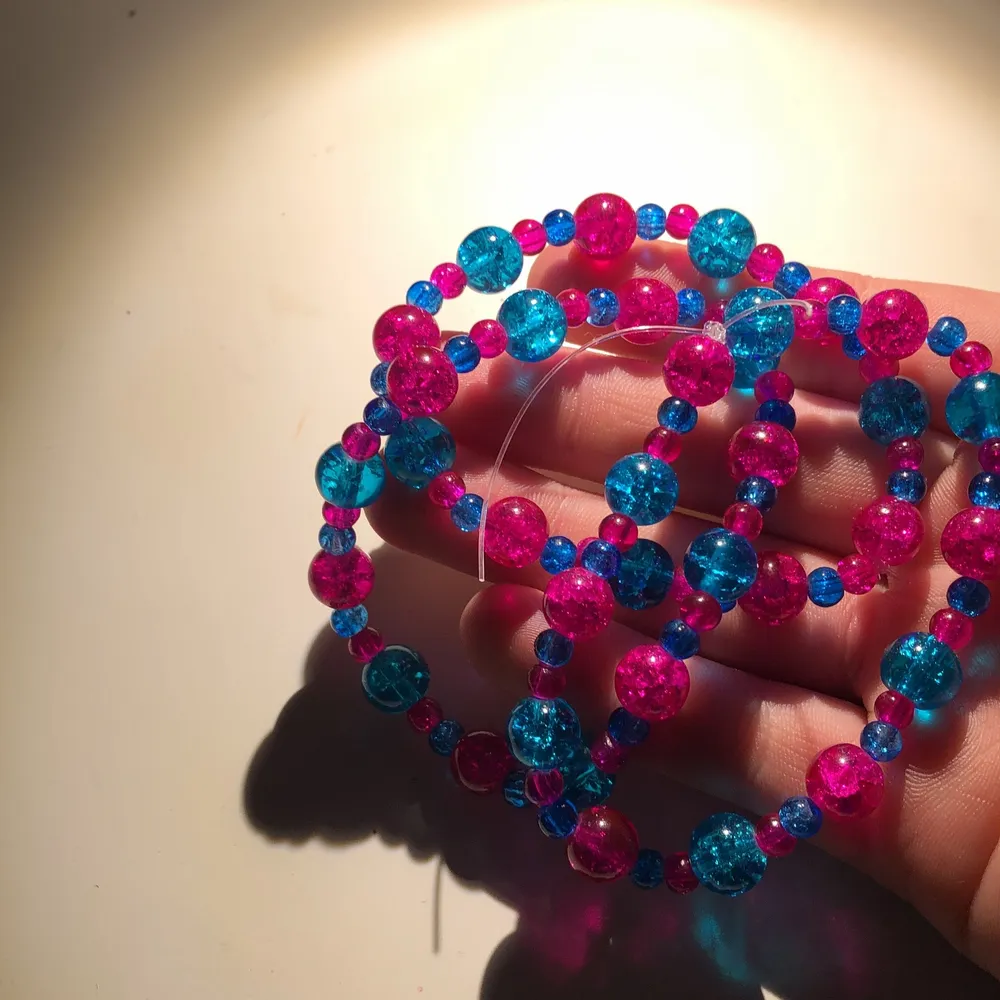 Armband gjorda av glas pärlor i blå och rosa.. Övrigt.