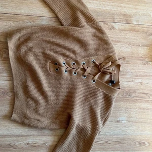 Stickad tröja - En stickad tröja med snörning där fram 