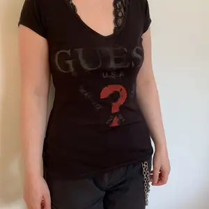 Svart Guess T-shirt i storlek medium, men passar även som S, med stort tryck för loggan på bröstet. Köpt i New York, välanvänd.