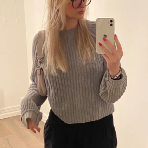 Grå stickad tröja  - Säljer min gråa tröja som är perfekt nu till sommaren på kyliga kvällar. Finns ett hål på baksidan från när jag skulle klippa bort lappen men syns knappt då det är långt upp i nacken. Om man vill kan jag även sy igen det innan den fraktas. 