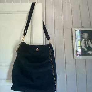 Svart väska  - Säljer denna snygga och rymliga väska från märket Unrika. Använd endast en gång. Lätt att bära o rymlig väska där allt får plats. Köp direkt för 150kr