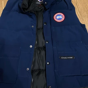 Canada Goose Väst Marinblå - Nästan oanvänd Canada Goose väst fi färgen marinblå. Billig då det osäkert om den är äkta eller inte. Bra skick.  Konsument står för frakt. 