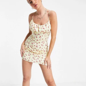 Blommarklänning Sommarklänning - En härlig gul mini sommarklänning med blommor och knytning i ryggen