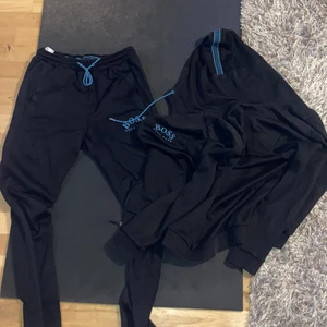 Hugo boss tracksuit  - Hugo boss tracksuit blå/svart, KÖPT FÖR 2500kr i emporia på ROOM , väldigt snygg dress, byxor knappt använde och koftan använd då och då, skick 9/10 fantastisk!
