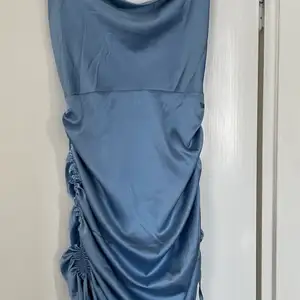 Silkesklänning i en superfin blå färg från märkes missguided i storlek 36.  Går att justera i längden med hjälp av knyten på sidorna.  Endast använd en gång och säljs då den inte passar mig längre.  