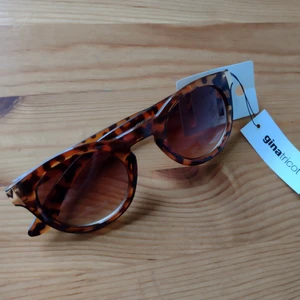 Oanvända bruna sköldpaddsmönstrade solglasögon - Oanvända solglasögon "Sofia, turtle" från Gina Tricot. Sköldpaddsmönstrade. Guldfärgad detalj på sidorna. Skickas spårbart eller med två frimärken (30 kr).