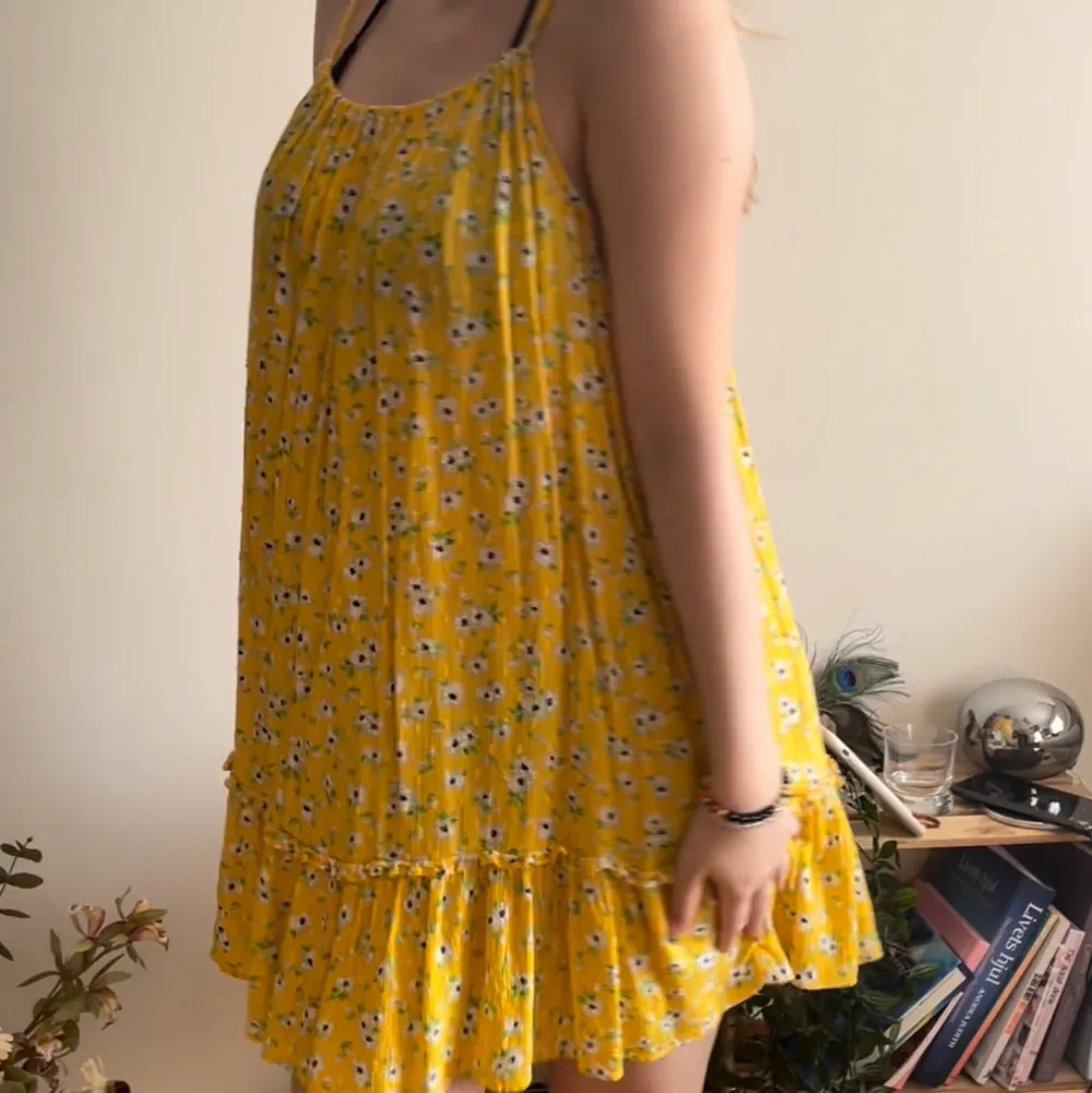 Otroligt fin och vacker gul fallande klänning med blommor. Perfekt nu under sommaren och är perfekt över en bikini. Den är lite genomskinlig i vissa ljus då det är en strandklänning. Bra kvalitet💕. Klänningar.