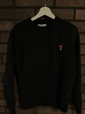 Ami Sweatshirt - En svart Ami sweatshirt i storlek S. Det är ett 3 cm håll i slutet av vänster ärmen! Använt skick! Nypris 2000 kr