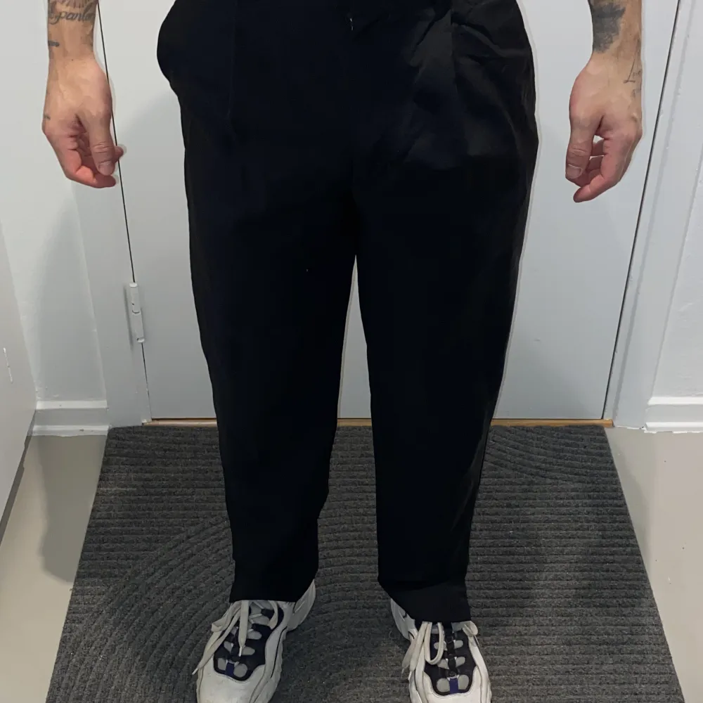 En svart kostymbyxa från Acne studios där jag sytt slits vid benets slut på ca 5 cm.  Sitter lite bredare runt lår för att smalna av lite nedtill. Supersnygg vardagsbyxa som lätt kan dressas upp också.   Passar mig perfekt som är 173 cm, 70 kg.. Jeans & Byxor.