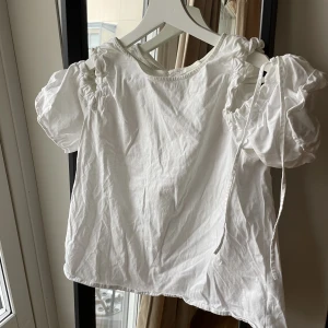 Vit topp - Hej! Här är en vit enkel topp med cutouts vid axlarna, den är begagnad men i bra skick och storlek s.