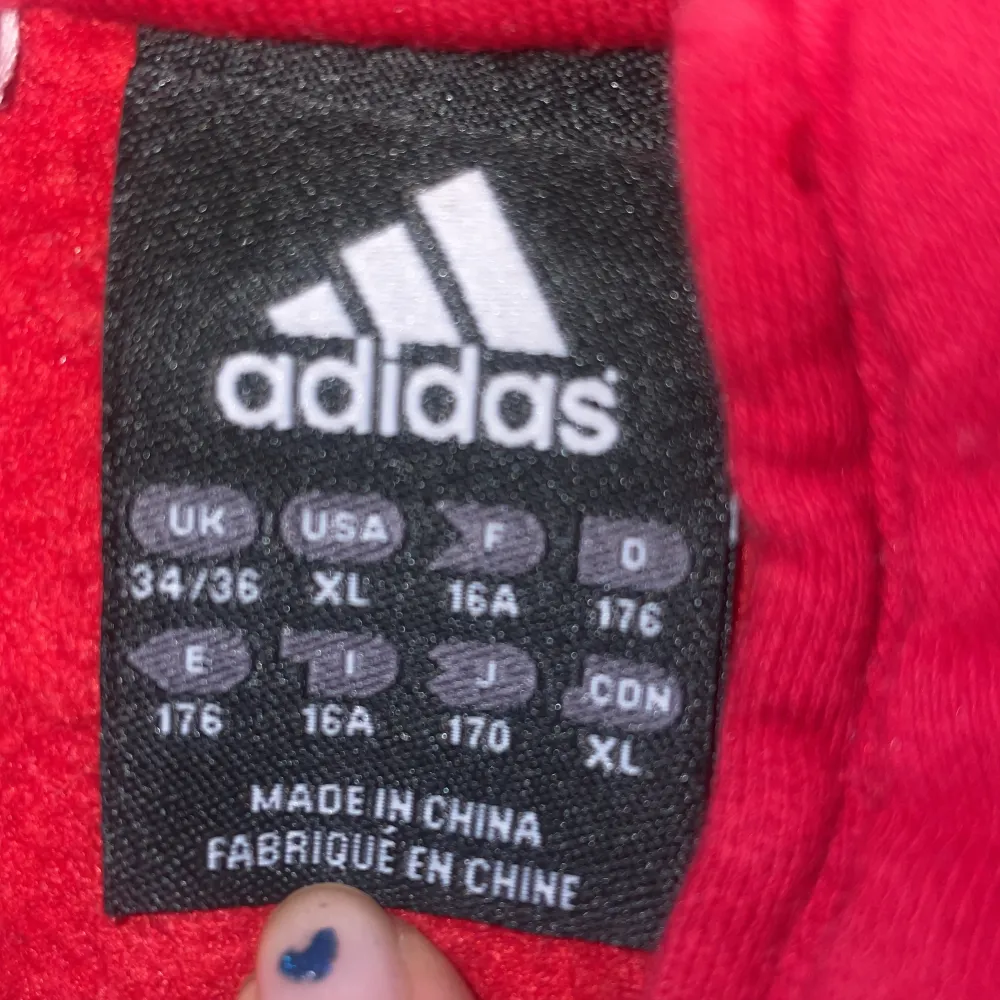 Röd adidas tröja, bra skick, storlek kan man se på sista bilden men enligt mig så är den som M och jag bär vanligt viss S och är 170cm lång, väldigt mjukt och tjockt material, säljer pga att den inte kommer till användning, säljaren står för frakt❤️❤️❤️. Hoodies.