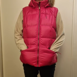 Rosa väst i dun Schöffel - Så härlig ceriserosa dunväst! Nyskick, Storlek 42. Tjock och varm. Fyllningen är 80% dun, 20% fjäder. "Skalet" är 100% polyester. 3 fickor med dragkedja (2 ute, 1 inne). Hör av dig om du vill ha fler bilder eller mer info! Kolla gärna mina andra annonser💓