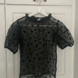 Svart blus stjärnmönster - Svart blus med stjärnmönster, see through, passar mig som har storlek XS-S, använd ett par gånger och är i fint skick⭐️ Köpare står för frakt.