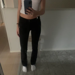 Svarta lågmidjade levis jeans - Riktigt snygga svarta lågmidjade bootcut jeans i storlek 24,32. Jag har sprätt upp dem för att de skulle bli lite längre. Väldigt bra skick och säljer då dem är lite korta för mig som är 1.68. Lapparna är svarta vilket jag tycker är en väldigt fin detalj.