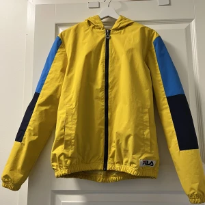Fila jacka storlek M  - En Fila jacka i storlek M. Är i bra skick men de delar som har resår är lite smutsiga invändigt (längst ner på jackan). Är en bra vindjacka.