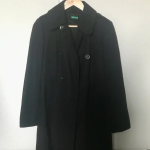 Benetton ny kappa M - Ny svart Benetton-kappa i strl ”42”, tajt i armarna och att knäppa så skulle snarare säga att den passar en 38-40. Obetydligt använd och i fint skick.  Katt finns i hemmet. Står ej för postens slarv. 