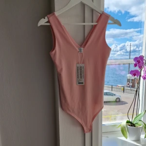 Rosa body - Rosa body från Amisu i storlek XS. Aldrig använd och med prislapp kvar. Stretchigt material.