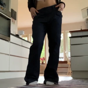 Mörkblåa lågmidjade bootcut kostymbyxor - Asfina lågmidjade mörkblåa kostymbyxor, ser svarta ut på första bilden men man ser lite bättre på andra:) långa på mig som är 160cm, bootcut