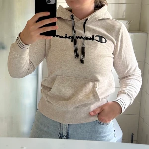 Hoodie från Champion i storlek S - Jättefin melerad Hoodie från Champion i storlek S. Lite gråaktig med svaga rosa toner. Använd endast ett fåtal gånger. 