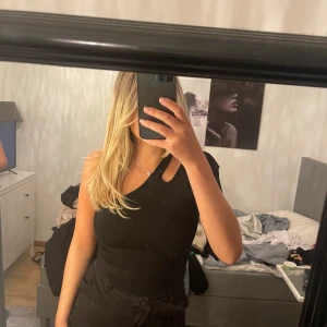 Svart topp - Säljer denna fina svarta topp som är från NA-KD, med riktigt fina detaljer som syns på bilden. Endast använd 1-2 ggr därför i toppskick.  