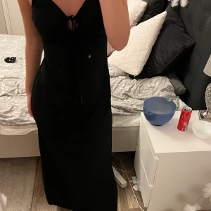 Svart långklänning  - Säljer denna oanvända svarta långklänning från mango i storlek Xs. Den går precis över fötterna på mig som är 170. Banden går ej att ändra så jag knyter dom för att banden är annars för långa. Köparen står för frakten 