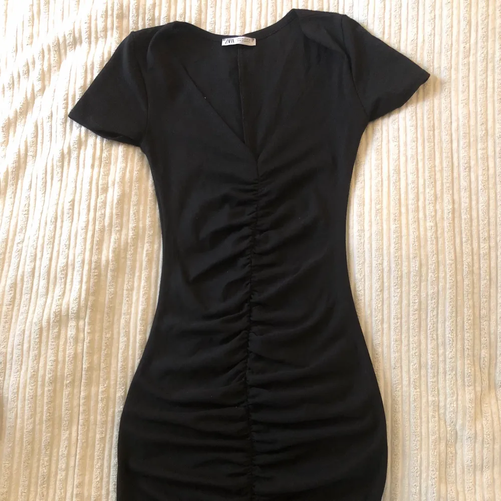 Helt ny oanvänd svart klänning från Zara i strlk S. Väldigt fint åtssitande längst kroppen med en urringning upptill.. Klänningar.