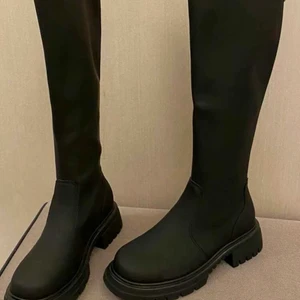 Knähöga stövlar med kedja bak  - Knähöga stövlar med kedja bak hela vägen. Sparsamt använda och är i nyskick. Strl 38 men känns som 36-37.