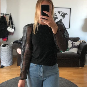 Blus Gina  - Svart blus med puffiga mesharmar i fint skick, stl S. Köparen står för frakten, kan mötas i Kalmar! 