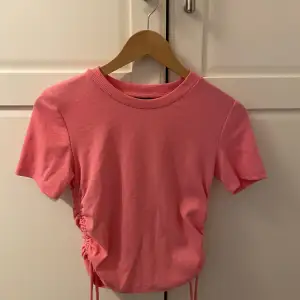 Rosa tröja med knytningar på sidorna