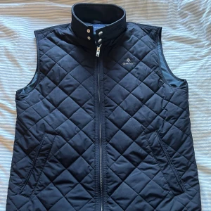 Gant Väst S-M - En väldigt skön höst/vår väst som håller värmen bra, Två innerfickor och utefickor Köpt på Gant Nordiska Kompaniet i Stockholm 2022 kollektionen,  använd Max 5 gånger:)  Passar S men sitter även bra på M!