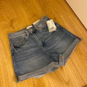 Blåa high waist jeans short ifrån HM i stl 36. De är helt nya och har prislappen kvar. Frakt ingår inte!