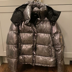 Silvrig puffer jacket - Säljer min fina silvriga puffer jacket som är slutsåld från bikbok. Den är i storlek L men sitter bra oversized på mig som har S/M i vanliga fall. Färgen är lite avskavd på vissa ställen som man kan se på bild 3. Men det är ingenting man tänker på när man har på sig jackan. Jättevarm och tjock perfekt till skidsemestern. Hör av dig för fler bilder!😊💗