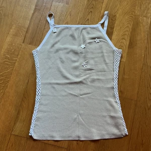 Y2k nätlinne  - Vintage Y2k linne med nät detaljer på sidorna och små söta blommor. 