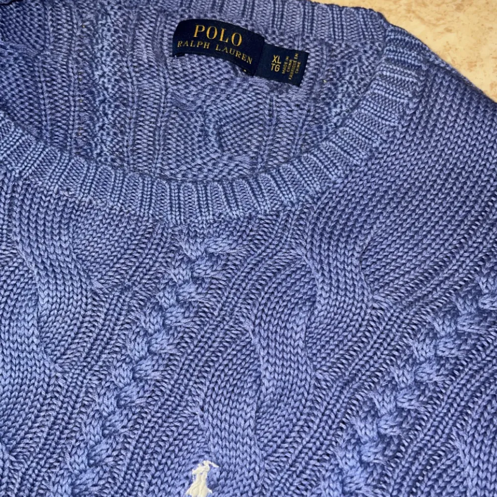Det är en stickad tröja från Polo Ralph Lauren! Som är blå/lila 💜💙Den är superfin och skön men kommer tyvärr till ingen användning. Köpte den i somras och det är toppen skick. Den är i XL men lite liten i storleken . Tröjor & Koftor.