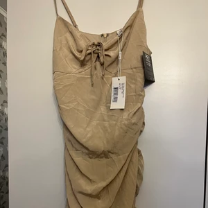 Super söt beige klänning - Söt beige klänning från Nelly! Prislapparna är fortfarande kvar och jag säljer den då den inte kommer till användning, den är i storlek xs och banden är även justerbara!🤍