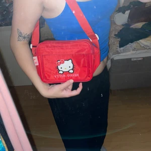 Hello kitty väska - Hello kitty väska, lunchbox formad och väldigt rymlig, typ två pocketböcker skulle få plats. Skit söt och justerbara band om man vill ha den lång elr kort. Ytterfack också