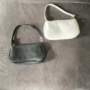 Axelväskor - En vit och en svart axelväska  Köp 1 för 80kr eller båda för 130kr Aldrig använda! 