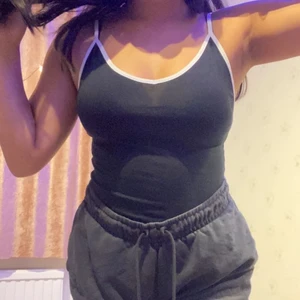 Svart body med vita stripes vid ärmar och underdel Storlek S - Köpt länge sedan men aldrig använd (för liten för mig som är storlek M) Passar folk med storlek XS och S, knappar vid nederdelen så man kan stänga, 