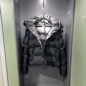 Burberry jacka - Säljer min oanvända Burberry Detachable Sleeve Hooded Puffer Jacket. Storlek M/L, jackans ärmar är avtagbara vilket gör det till en väst. Köpte jackan 1 år sedan och säljer den då den tar plats i garderoben. Endast mottaglig för seriösa köpare. 