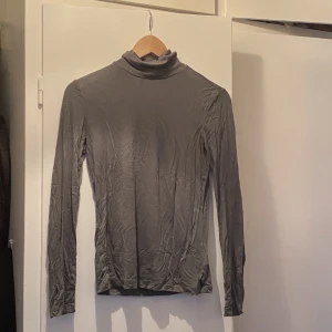 Grön polo i tunn bomull  - Skön polo att ha under något eller som den är. Mossgrön 