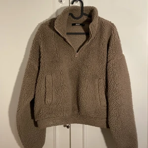 Mjuk tjocktröja  - En brun fluffig tjocktröja från BikBok. Använd några gånger men fortfarande i fint skick. 1/4 dragkedja vid halsen och gummiband längst ner om man vill ha som en mudd eller om den ska vara rak. 